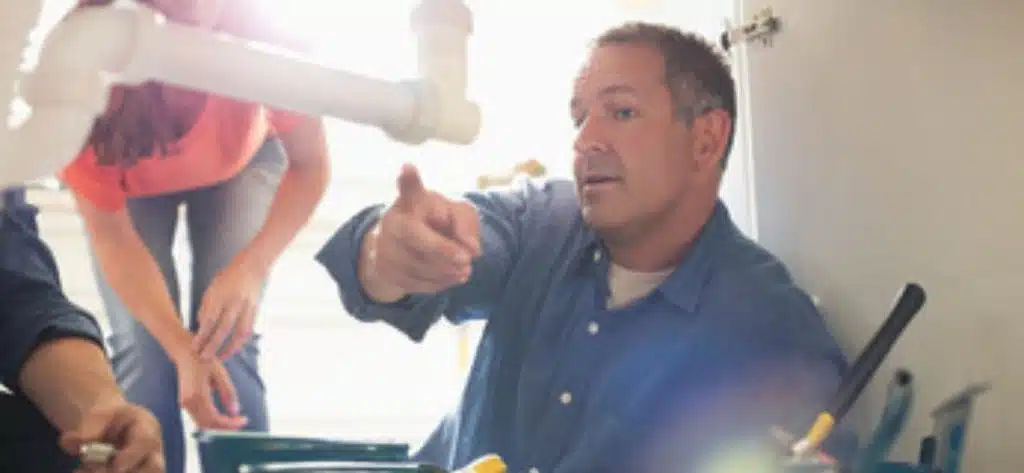 plumber on floor sorting water pipes